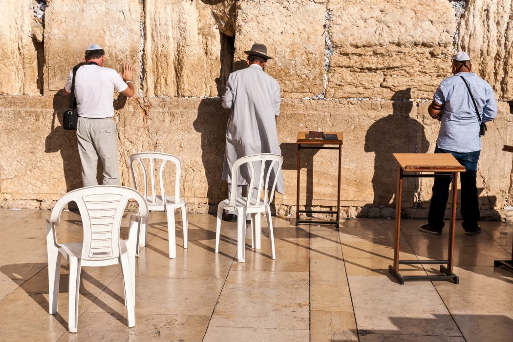 Men praying in front of the Wailing Wall