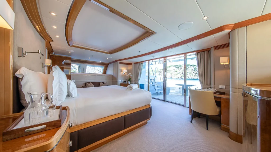 Master cabin aboard superyacht Alamshar featuring a large bed and direct access to the aft deck