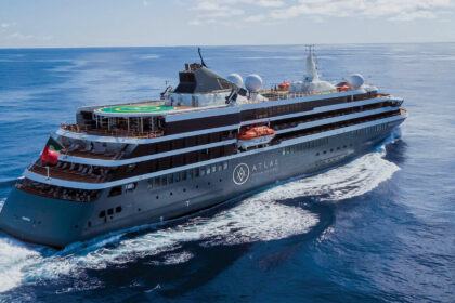 Atlas Ocean Voyages expedition cruise ship sailing through open ocean, showcasing its helipad, exploration-focused design, and premium small-ship layout.