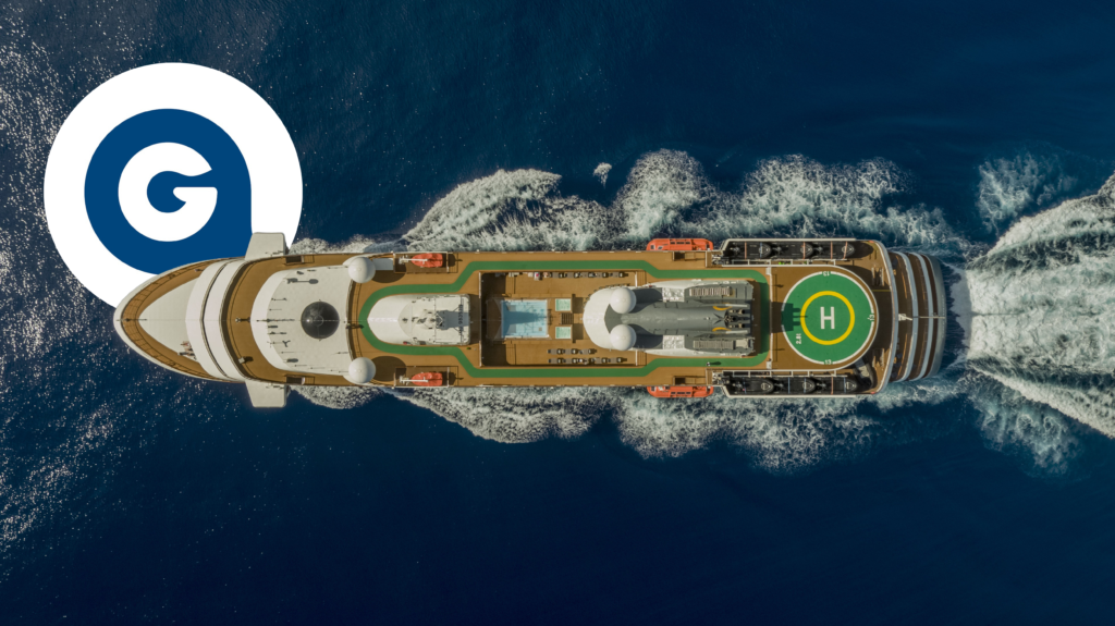 Aerial top-down view of an Atlas Ocean Voyages expedition cruise ship sailing through deep blue ocean waters, showing the helipad and open deck layout.