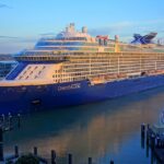 Celebrity Edge cruise ship docked at port during early evening, showing the Edge-Class vessel’s distinctive angular design
