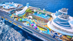 Aerial view of Royal Caribbean’s Icon of the Seas featuring a full waterpark, multiple pools, and colorful deck attractions at sea.