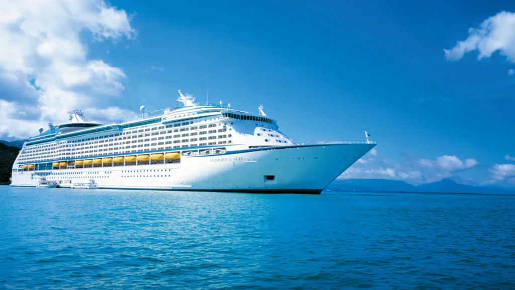 Royal Caribbean’s Voyager of the Seas cruise ship sailing in clear blue waters under a bright sky, marking its arrival in Brisbane for winter deployment.
