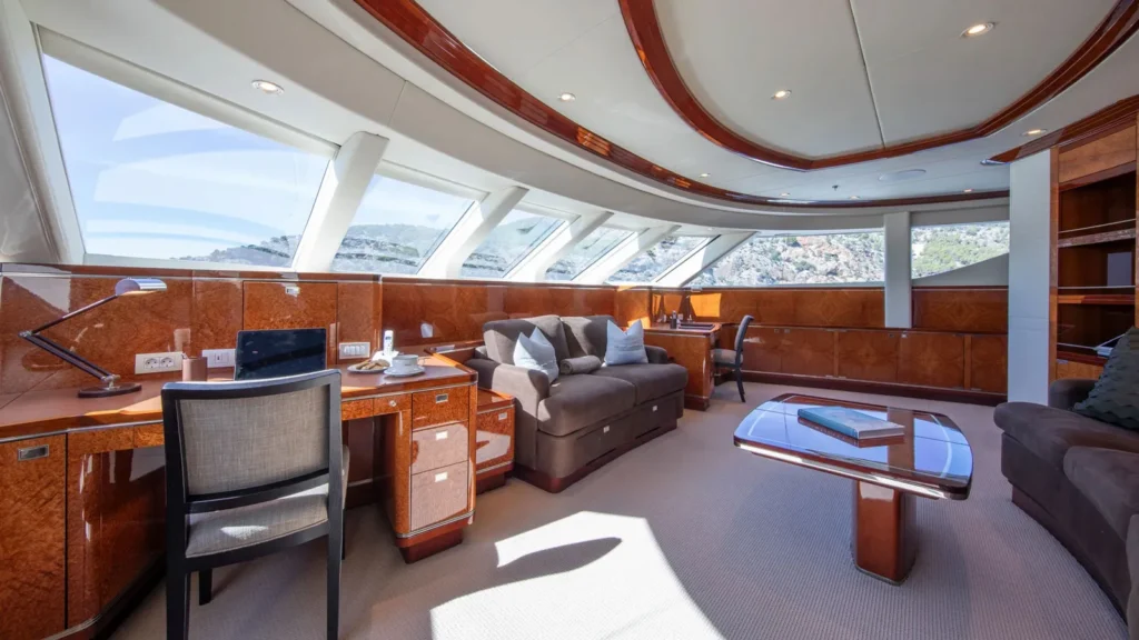 Interior view of superyacht Alamshar’s wheelhouse featuring panoramic windows and polished wood finishes