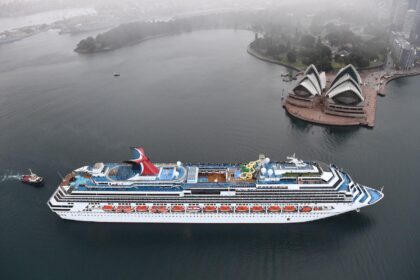 Aerial view of Carnival Splendor cruising through Sydney Harbour with the Sydney Opera House in the background