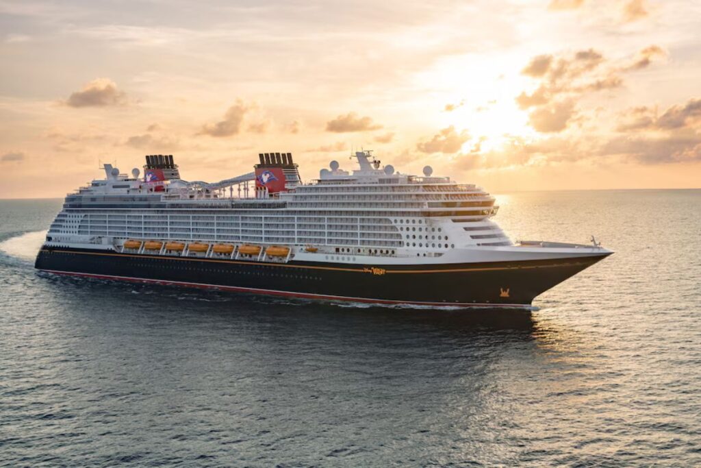 Disney Cruise Line ship sailing at sunset during fleet expansion