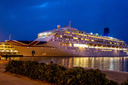 MV Piano Land cruise ship illuminated at night while docked in Hong Kong harbor ahead of its regional return to Asia