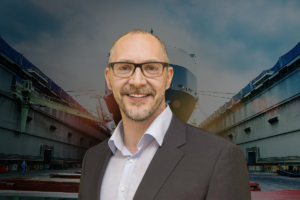 Roland Schwandt, newly appointed CEO of Schottel, pictured at a shipyard with a vessel under construction in the background.