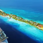 Aerial view of Royal Caribbean’s new Beach Club at Paradise Island in Nassau, showing turquoise waters, landscaped beachfront areas, and a cruise ship docked nearby.