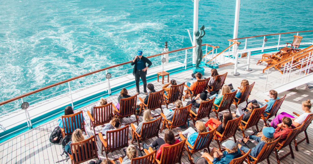 Students participating in an outdoor class aboard the Semester at Sea ship while sailing at sea during a global academic voyage.