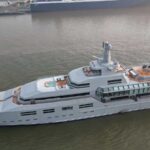 The 90-metre superyacht Norn underway in coastal waters, showcasing its modern expedition-style design and helipad