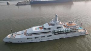 The 90-metre superyacht Norn underway in coastal waters, showcasing its modern expedition-style design and helipad