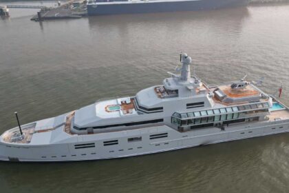 The 90-metre superyacht Norn underway in coastal waters, showcasing its modern expedition-style design and helipad