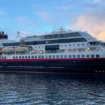 Hurtigruten ship sailing through Norwegian fjords during Arctic voyage