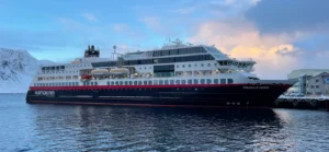 Hurtigruten ship sailing through Norwegian fjords during Arctic voyage