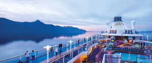 Royal Caribbean cruise ships sailing through Alaska with glaciers and mountain scenery